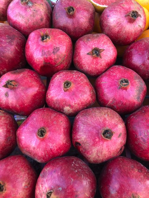 Free Vibrant red pomegranates neatly arranged at a market stall in Marrakech, Morocco. Stock Photo