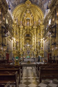 Stunning interior of a Baroque church, featuring intricate gold embellishments and religious art.