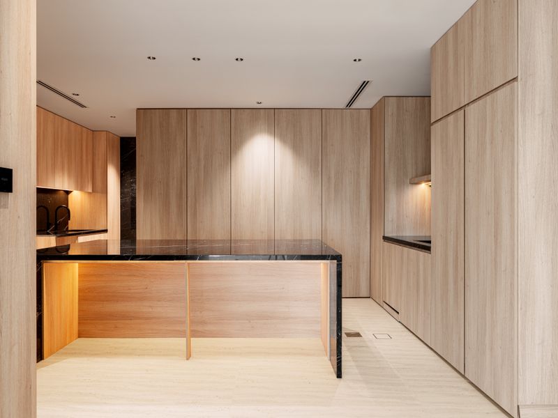 Sub-Zero unit that needs same-day repair Sleek modern kitchen design featuring wood paneling and black marble countertops