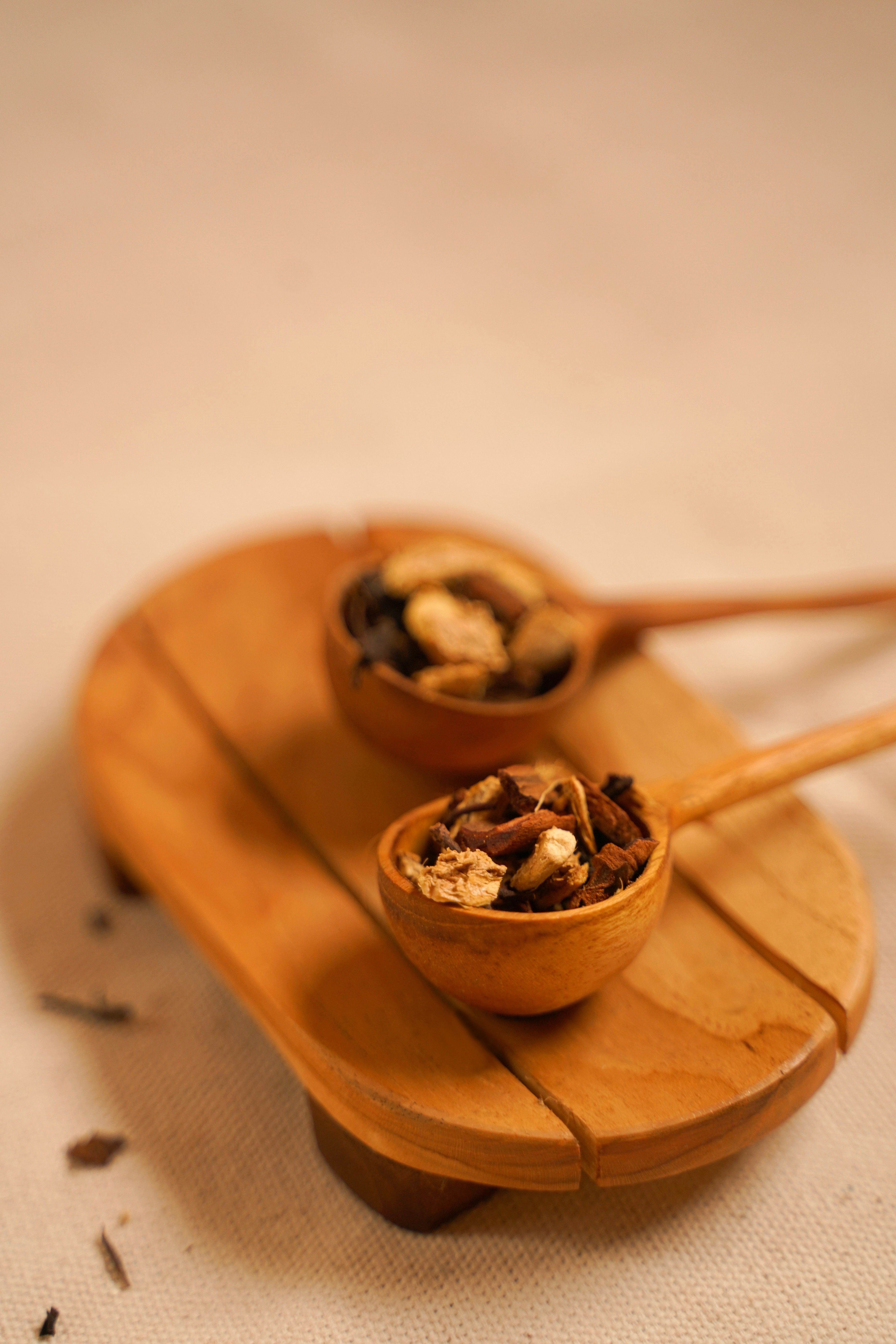 Fotomural Imagen de tonos cálidos de mezclas de té rústico en cucharas de madera sobre una bandeja para servir, creando un ambiente acogedor.
