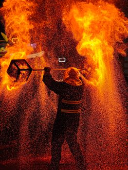 Stunning fire performer with flames and sparks in a nighttime show.