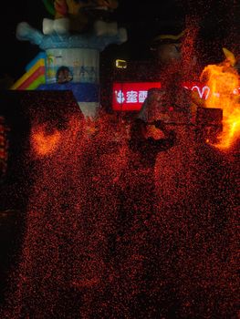 Dynamic night festival with dramatic fire display and colorful lights.