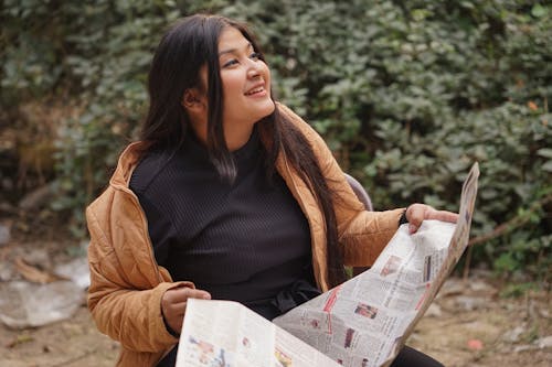 Free Asian Woman Holding a Newspaper Stock Photo