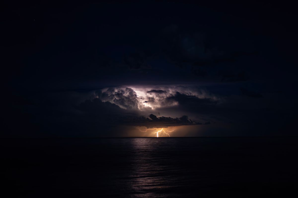 Dramatic Lightning Strike Over Tranquil Sea · Free Stock Photo