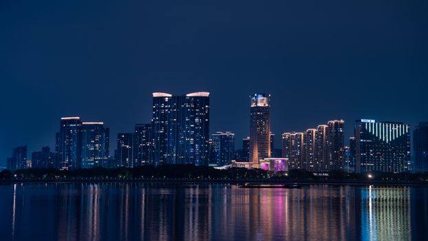 Stunning night view of the Hangzhou skyline reflected in the Qiantang River.