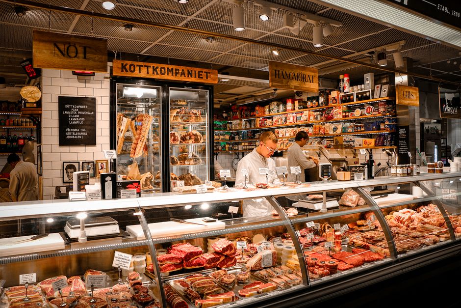 A vibrant butcher shop counter in Stockholm, Sweden, featuring various fresh meats and products
