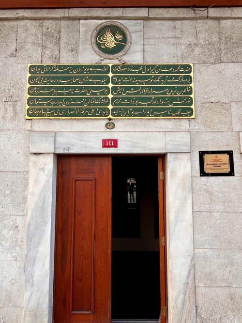 Free Marble entrance with wood door and distinctive Arabic script signage. Stock Photo