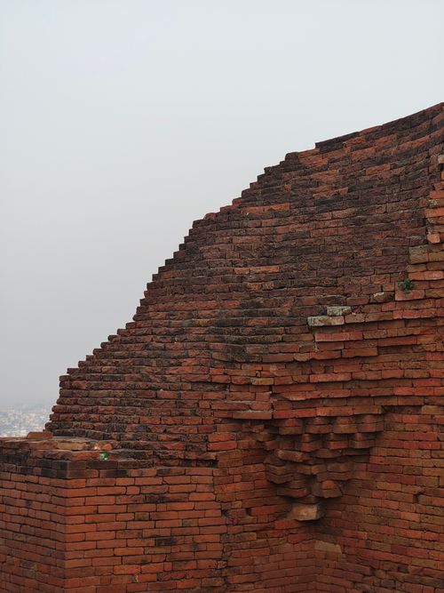 Free Close-up view of historical brick structure with weathered texture and muted sky background. Stock Photo
