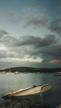 A tranquil boat scene at Sığacık Harbor in Türkiye during twilight, depicting a peaceful and moody atmosphere.