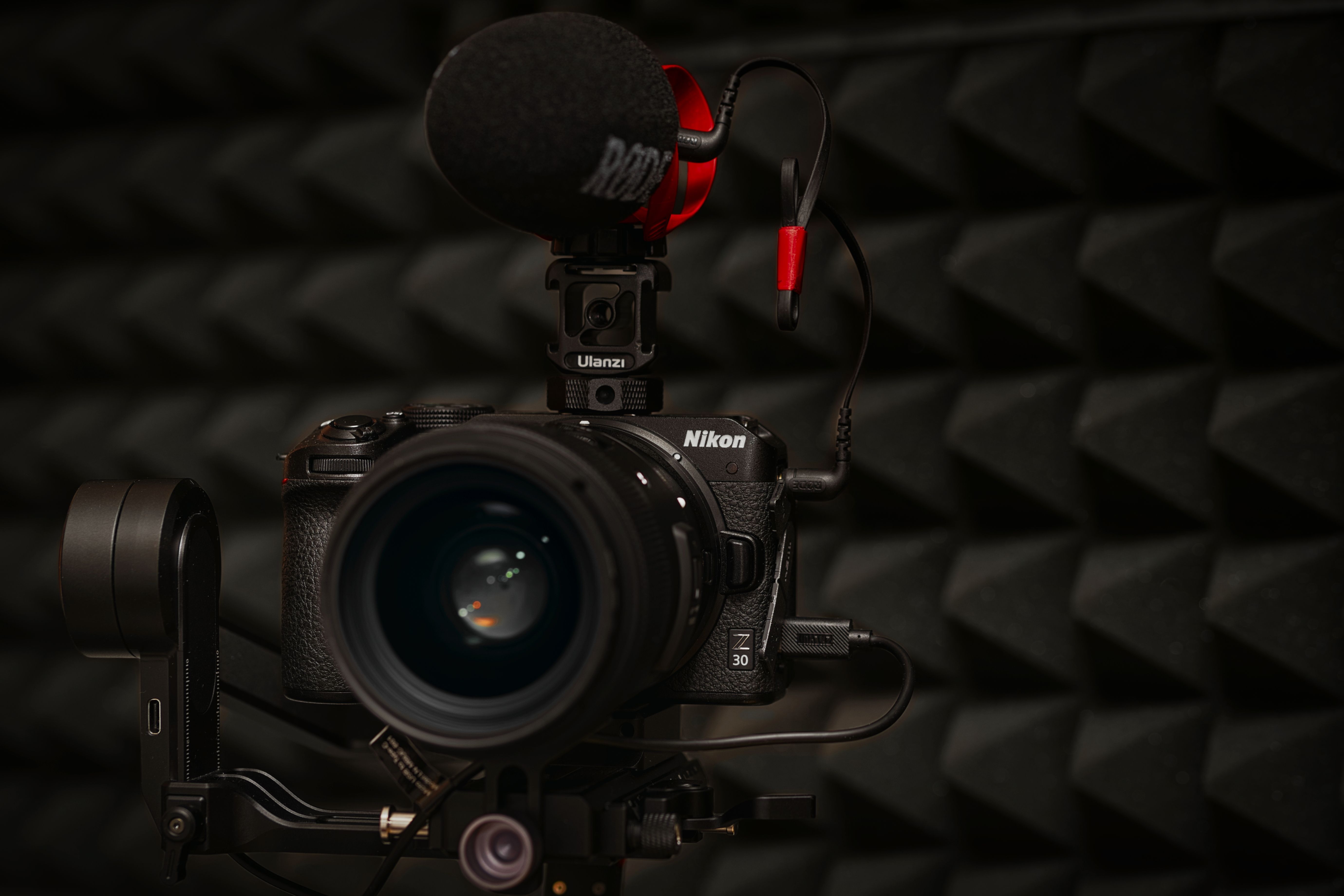 Close-up of a DSLR camera with microphone setup in soundproof studio environment.