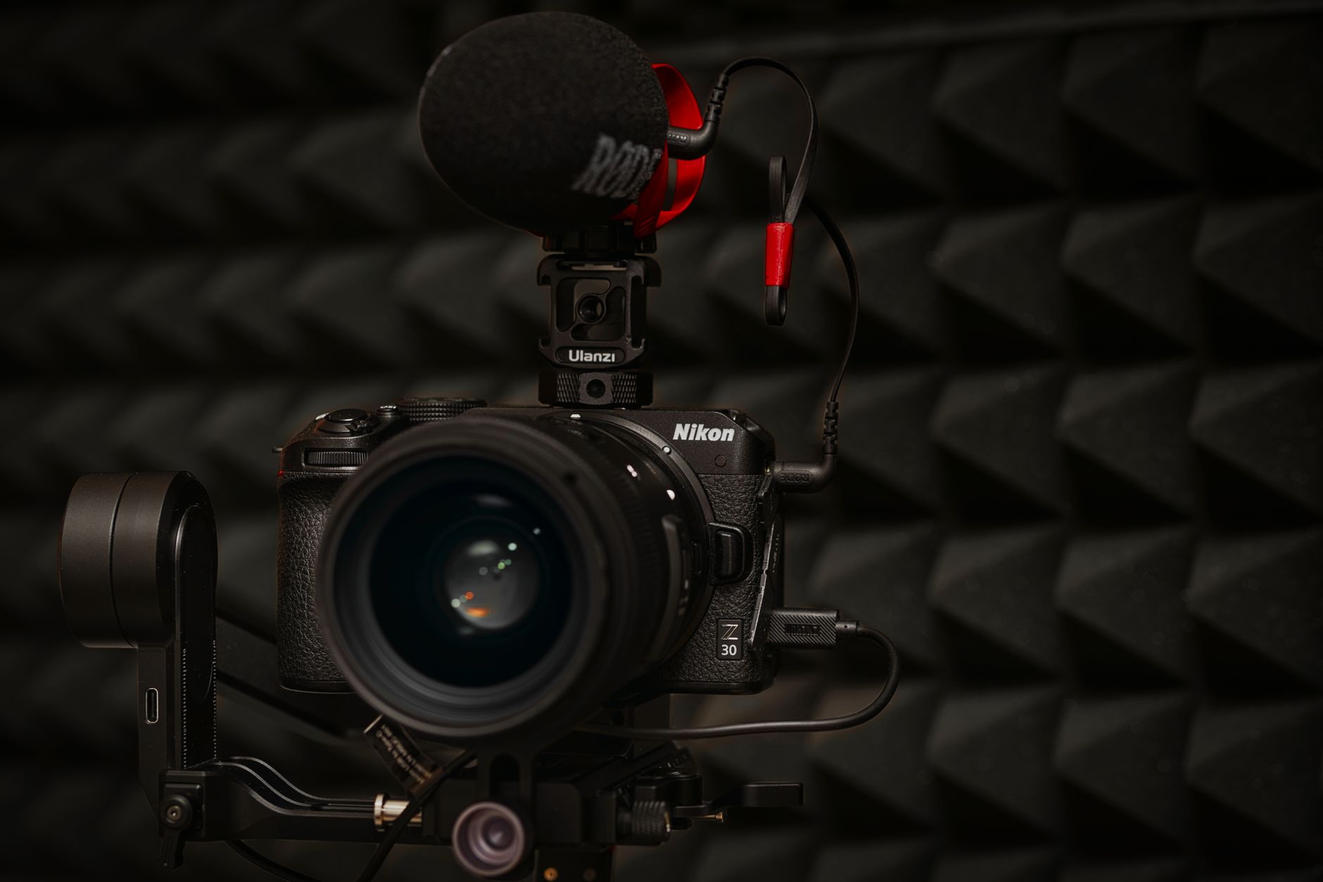 Close-up of a DSLR camera with microphone setup in soundproof studio environment.
