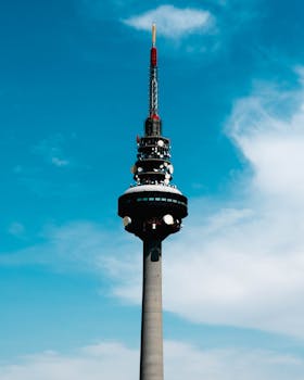 Striking view of the Madrid Torrespaña communication tower under a vibrant blue sky.