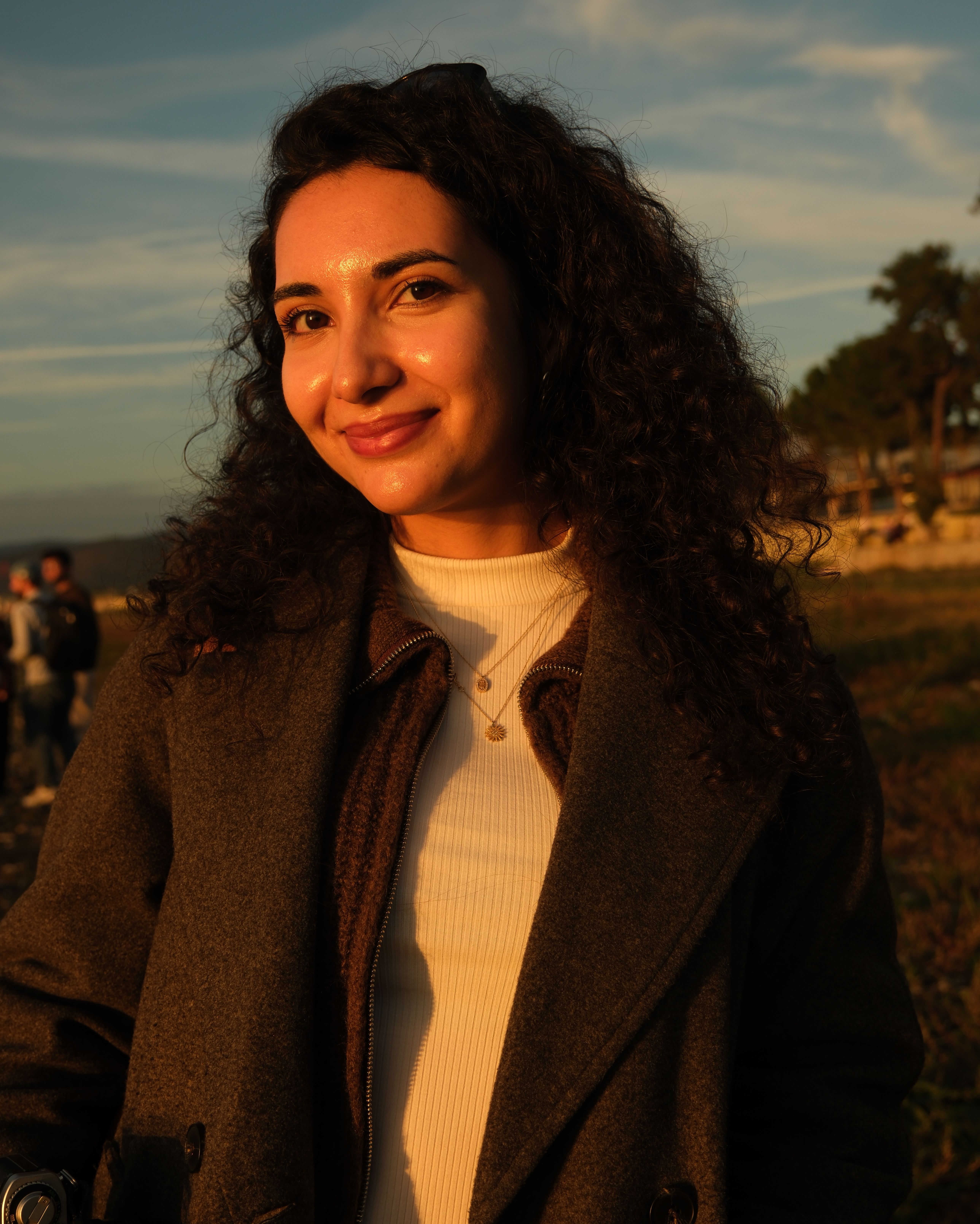 Charming portrait of a woman during sunset with a warm, natural backdrop.