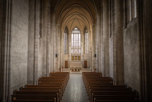 Free Explore the serene beauty of a grand Gothic-style cathedral with stunning arches and stained glass windows. Stock Photo