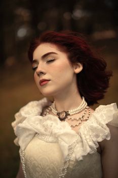 Elegant portrait of a woman with red hair in Victorian attire outdoors.. elegant, portrait, woman