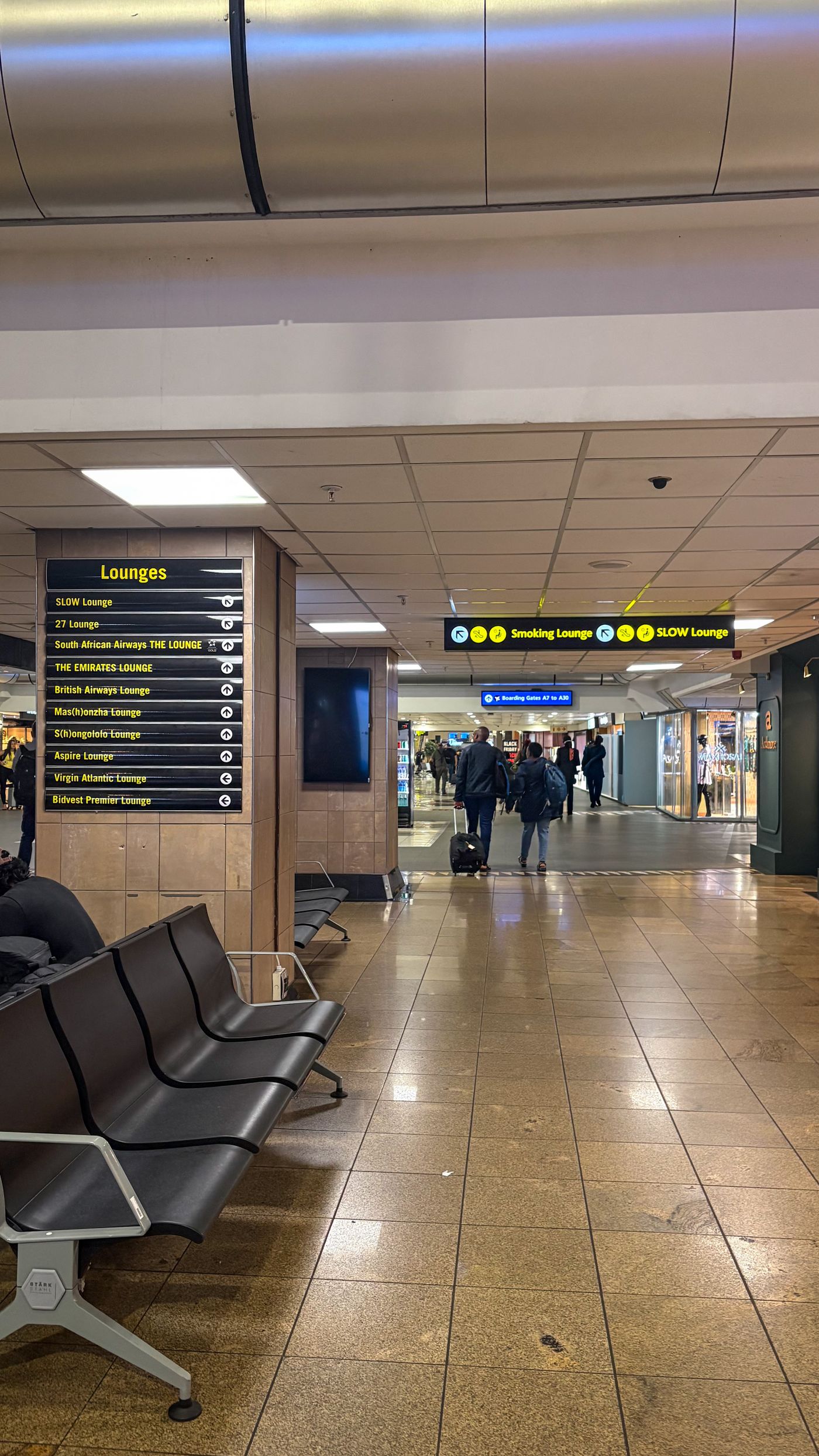 Modern airport interior with seating and lounge signage