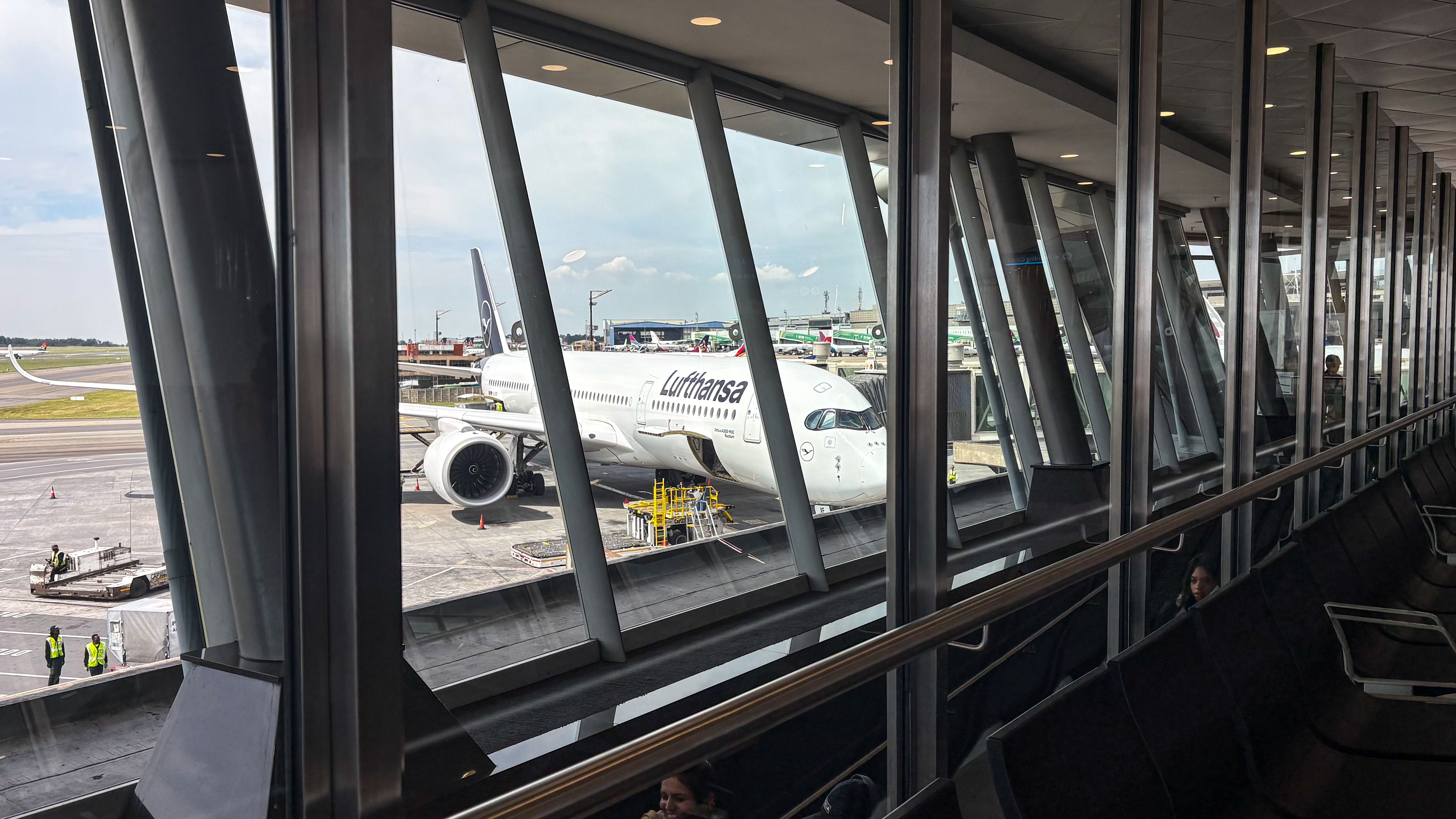 Gratis Udsigt over et passagerfly ved en lufthavnsgate klar til boarding gennem terminalvinduerne. Lagerfoto