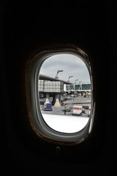 A view of airport activity captured through an airplane window.