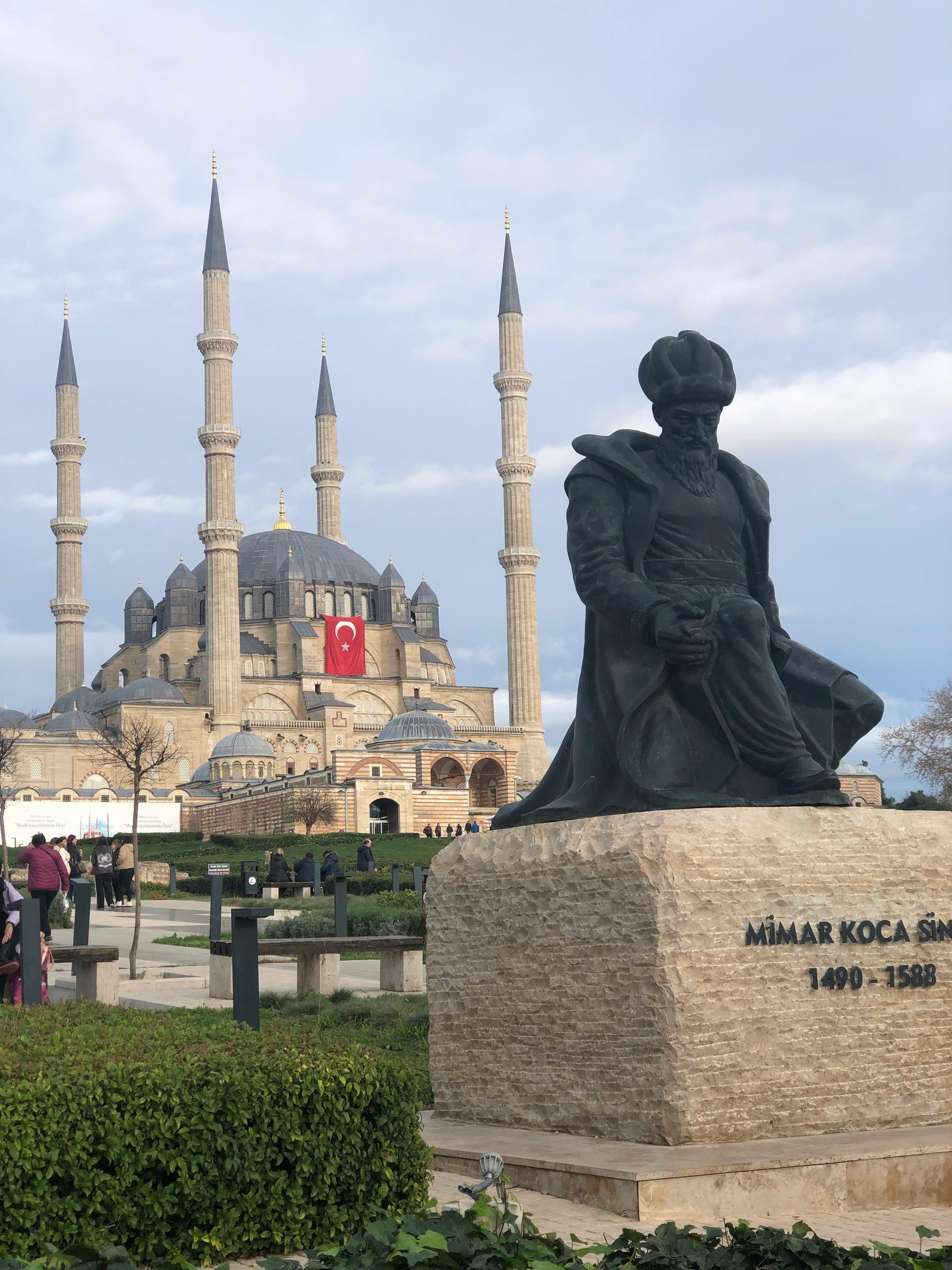 View of Selimiye Mosque and Sinan statue in Edirne, Turkey, with clear blue sky.