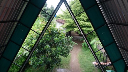 Free Scenic view through triangular roof architecture to a lush backyard with greenery. Stock Photo