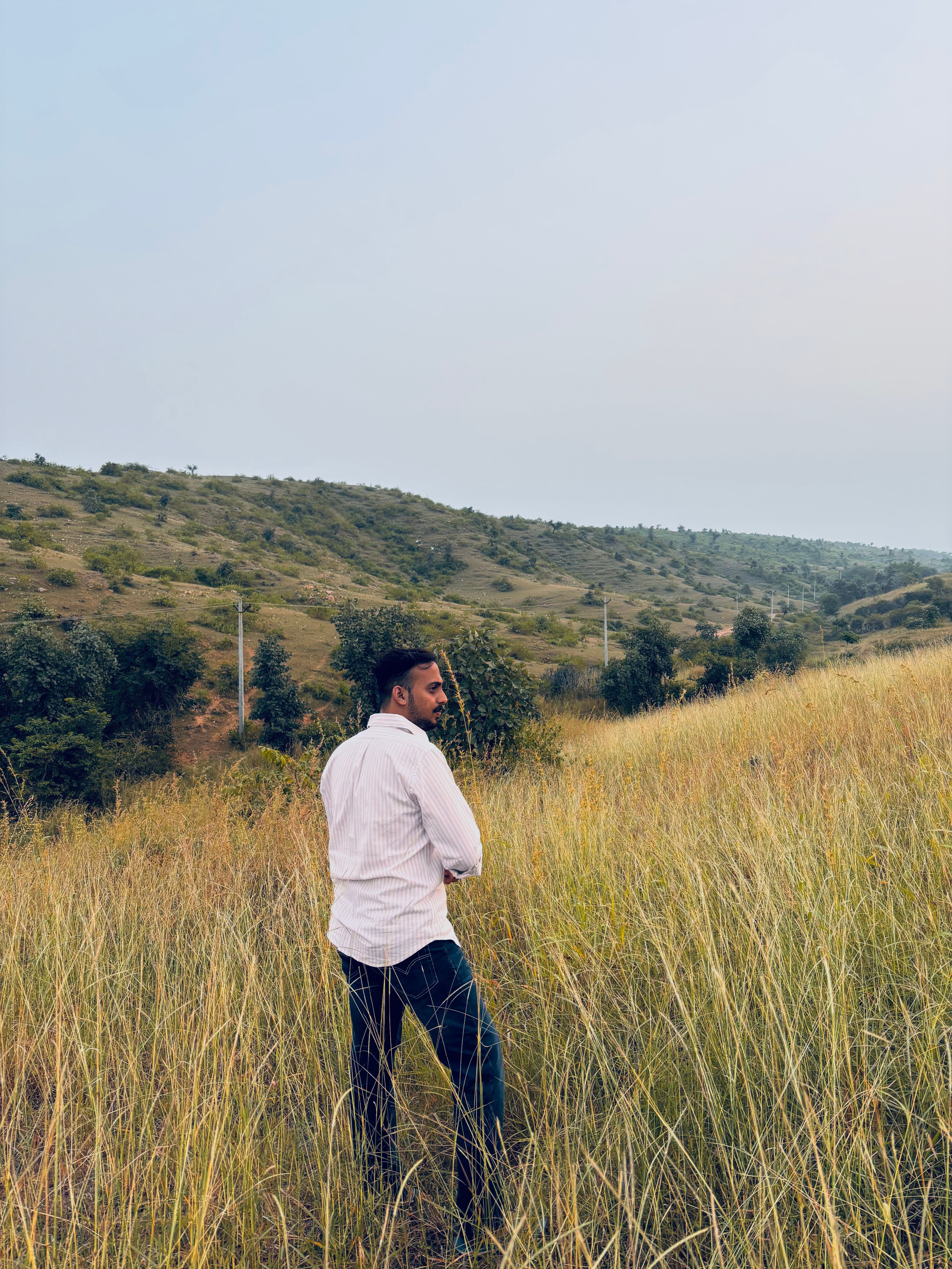 A man gazing into the distance on a serene hillside in Udaipur, India.