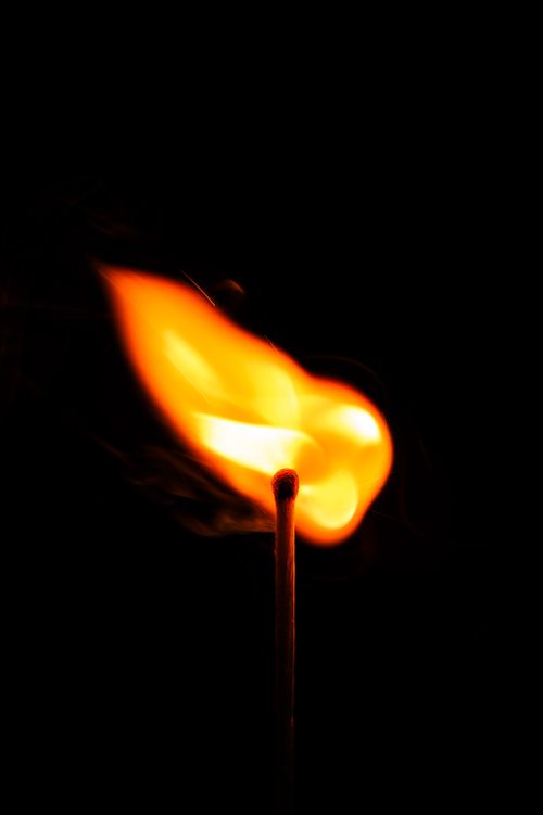Free A matchstick ignites brightly against a dark background, showcasing the vibrant flame. Stock Photo
