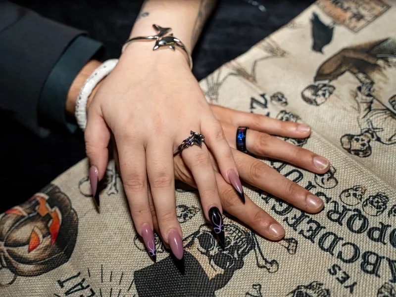 Halloween-themed press-on nails with orange and black designs