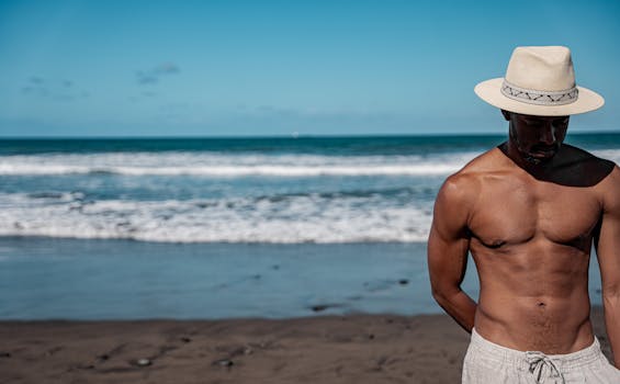 A man enjoying a sunny day at the beach in the Canary Islands, wearing a straw hat.
