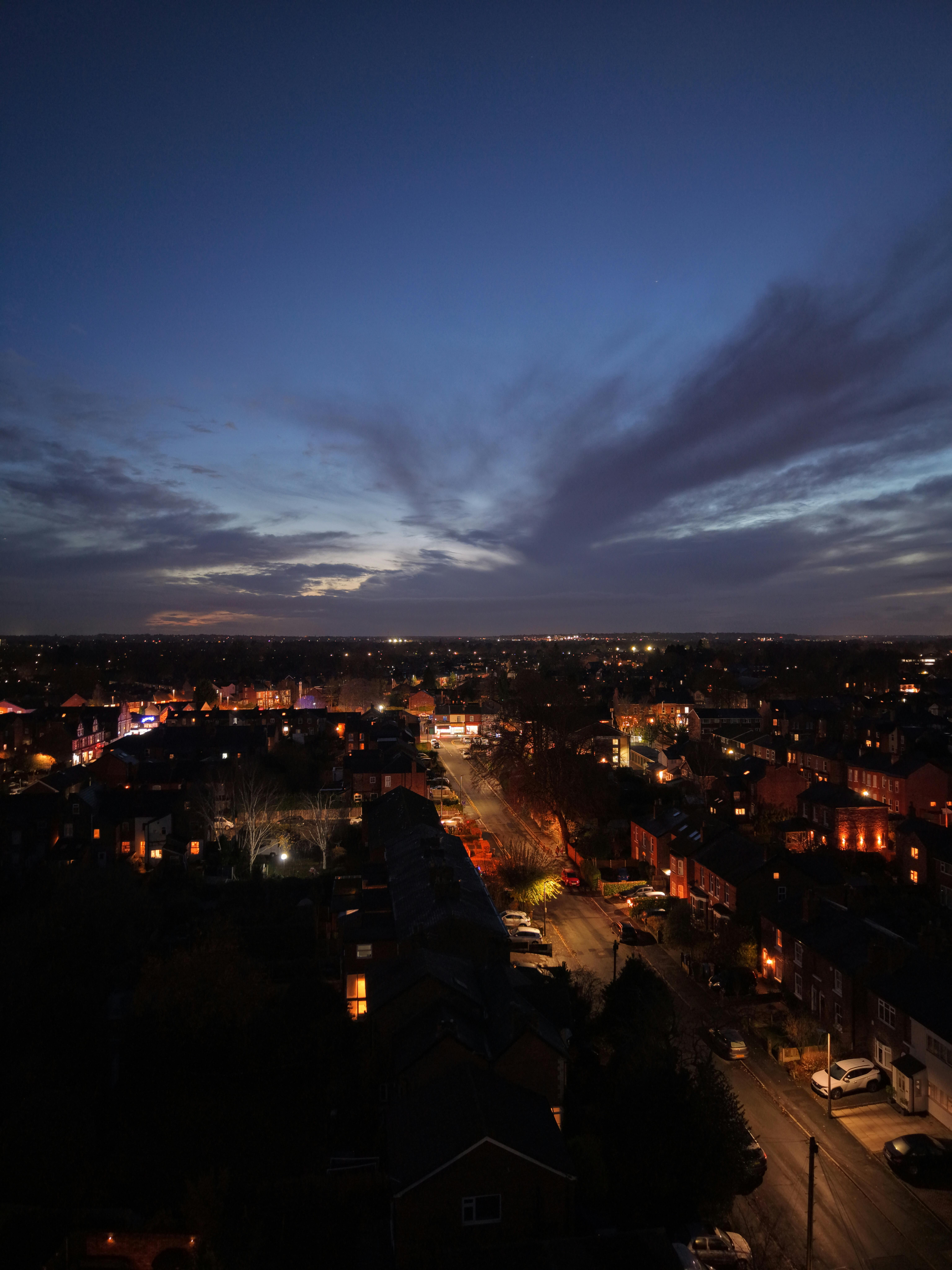 grátis Captura de uma paisagem urbana com postes de luz brilhando ao entardecer. Foto profissional