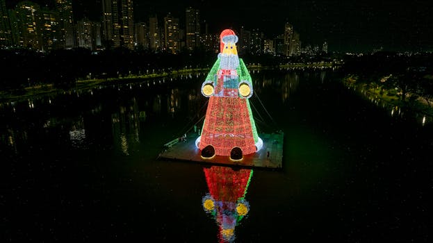 Illuminated Santa Claus with gift at Igapó Lake, Londrina, Brazil, during Christmas night.
