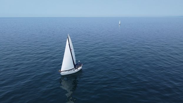 Aerial view of sailboats navigating the calm waters of Lake Michigan on a clear summer day.