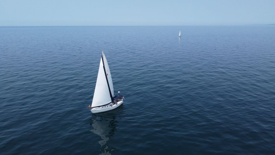 Aerial view of sailboats navigating the calm waters of Lake Michigan on a clear summer day.