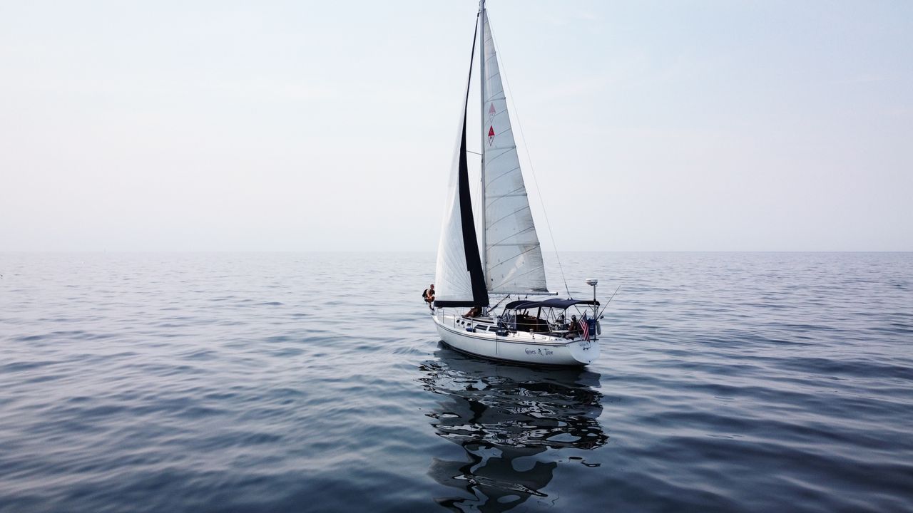 a solitary sailboat gracefully navigates the calm waters of lake michi