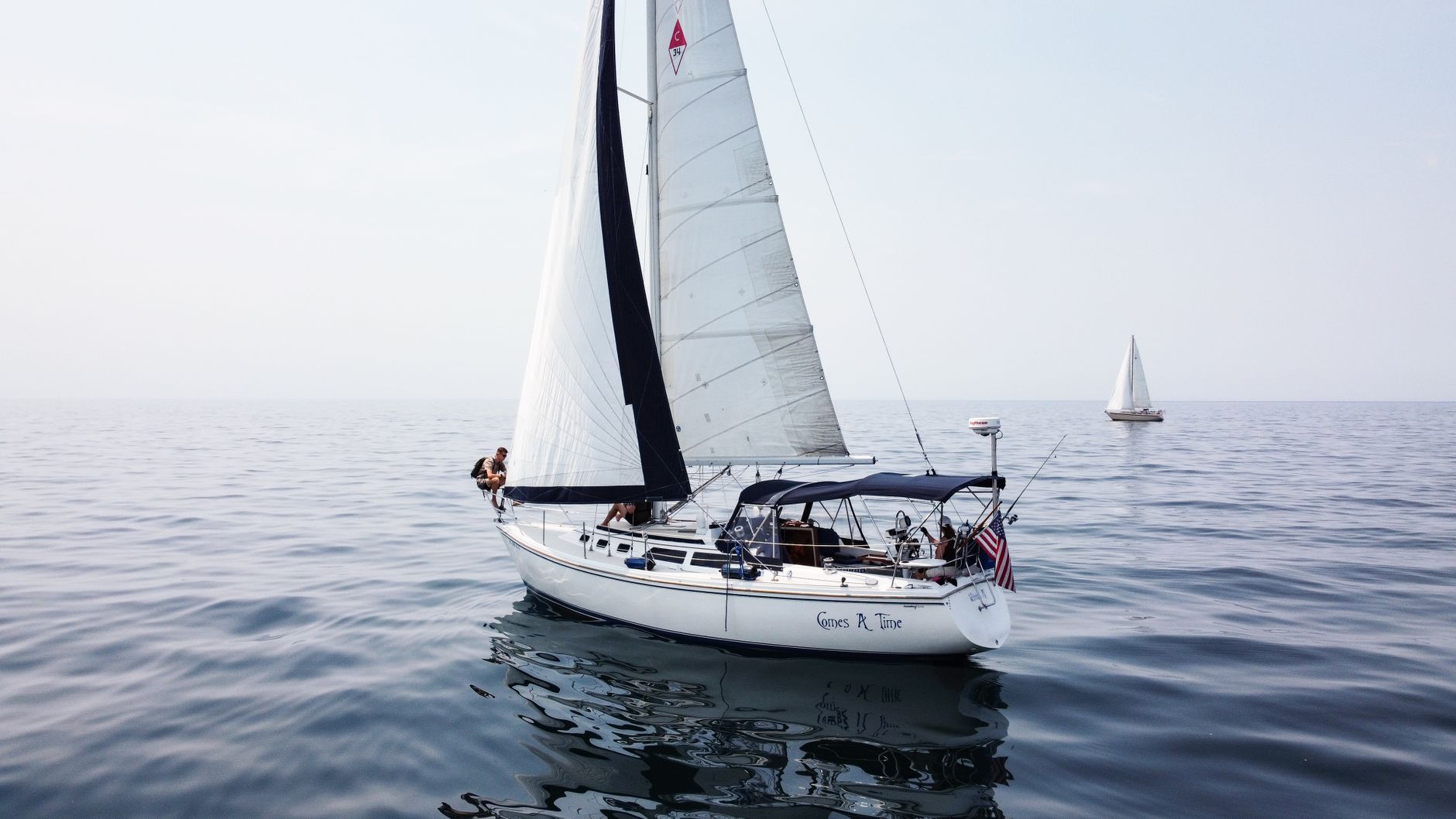 Two sailboats navigate the tranquil waters of Lake Michigan, embodying a serene sailing adventure.