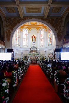 Stunning architecture inside a church with floral decorations and red carpet.