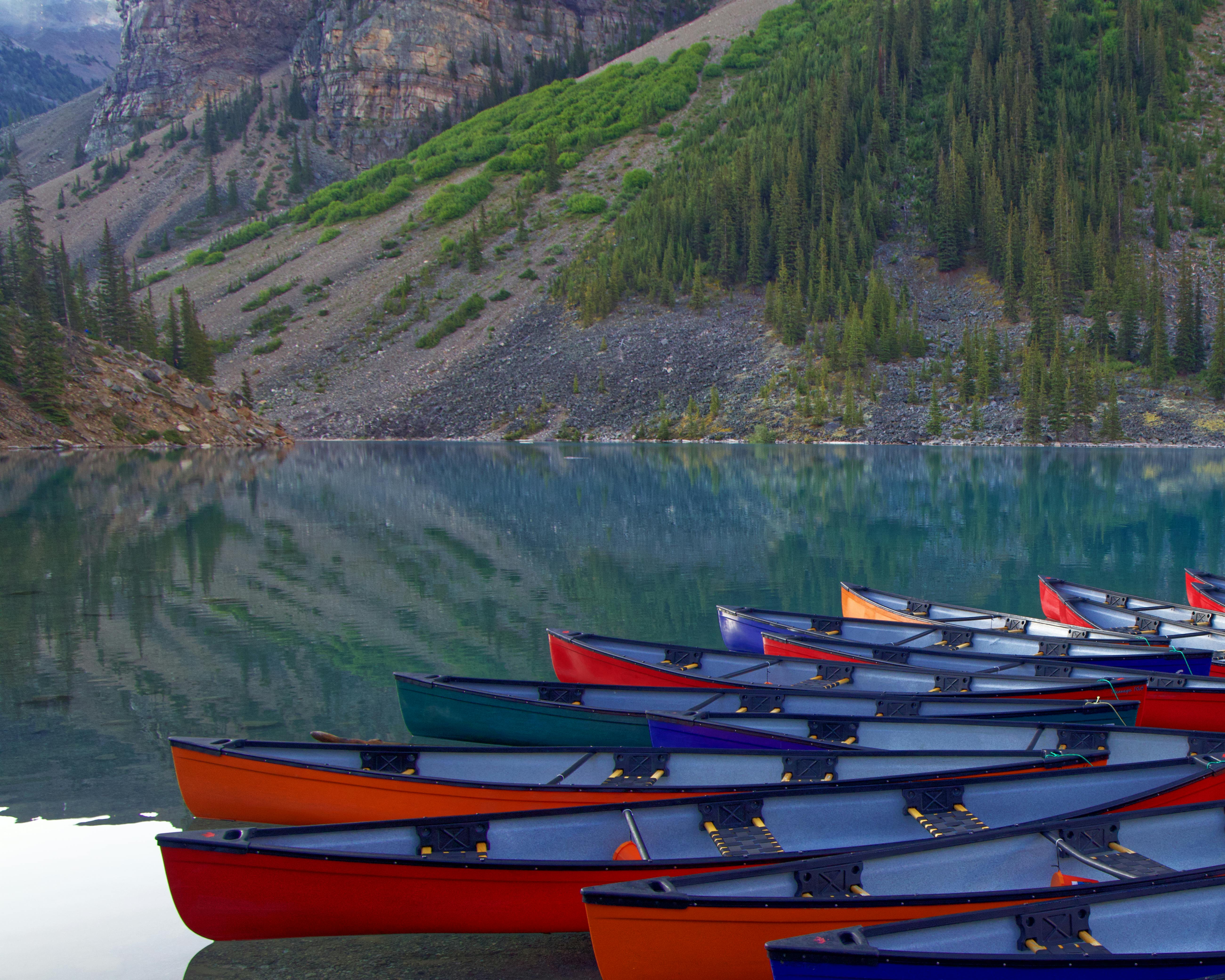 Vibrant canoes at a serene mountain lake, perfect for outdoor adventures.