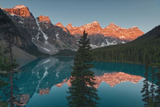 Stunning sunrise view of Moraine Lake reflecting the Valley of the Ten Peaks in Banff National Park, Canada.