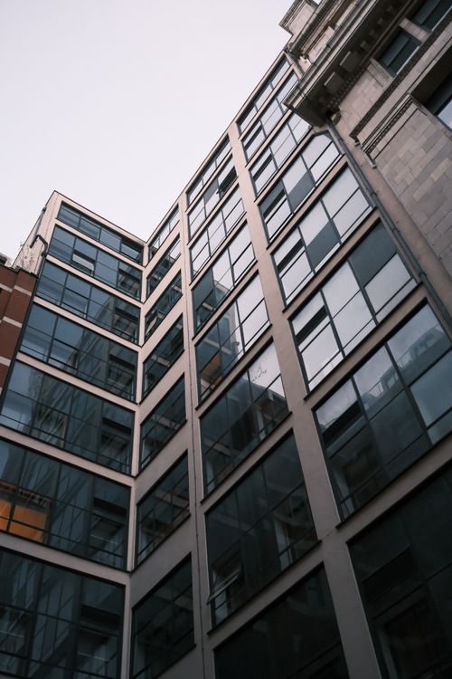 Free Contemporary city building with reflective glass facade and geometric design, perfect for urban aesthetics. Stock Photo
