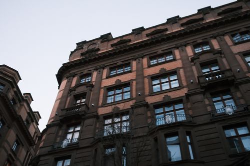 Free Low angle view of a historic building facade with decorative architecture details in an urban setting. Stock Photo