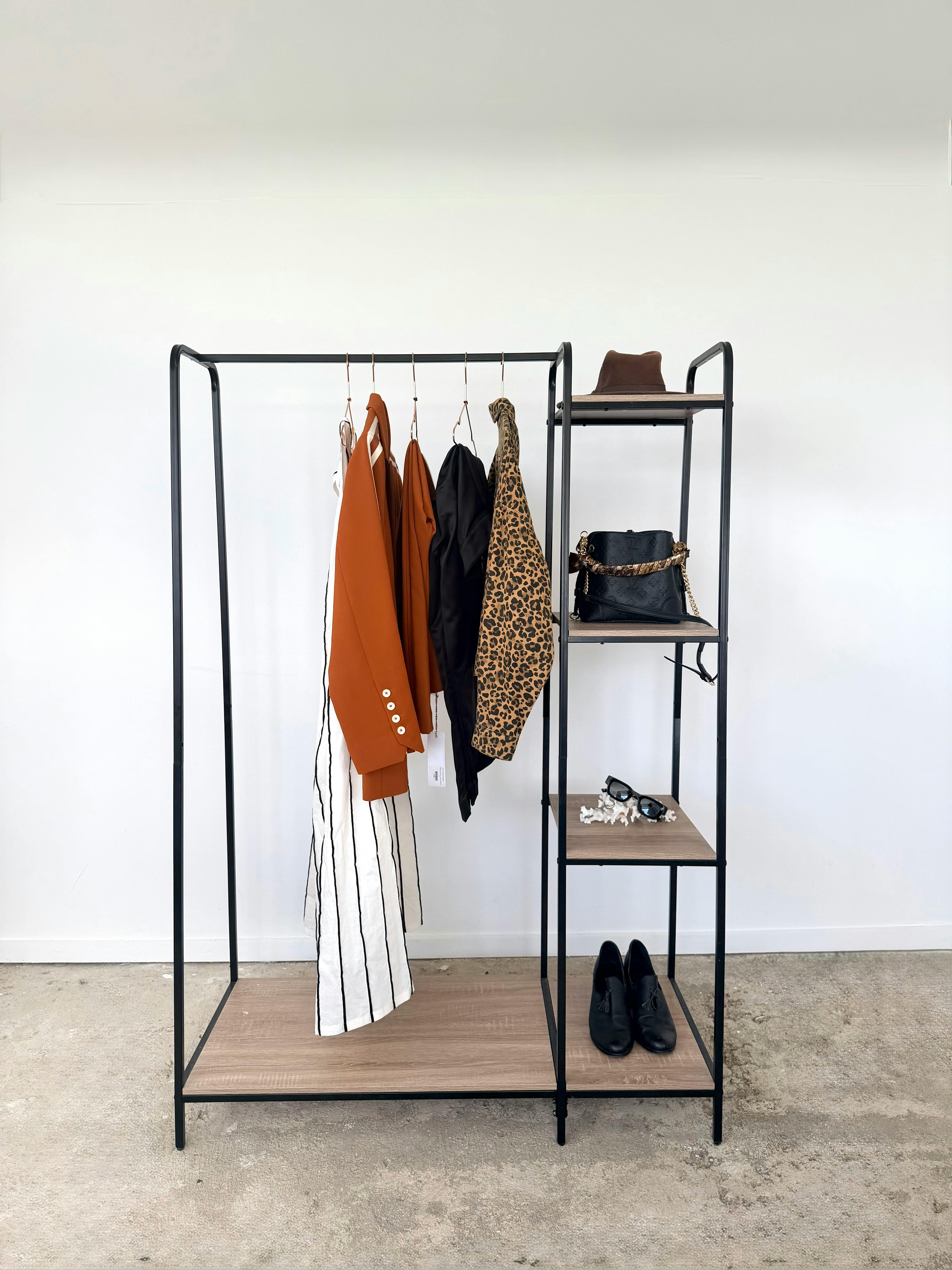A modern minimalist wardrobe rack showcasing stylish clothing and accessories.