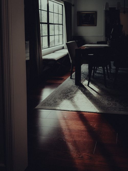 Free Atmospheric indoor scene with sunlight casting shadows on a wooden floor, creating a warm and inviting mood. Stock Photo