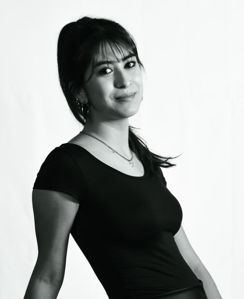 Free Black and white portrait of a young woman smiling against a plain background. Stock Photo