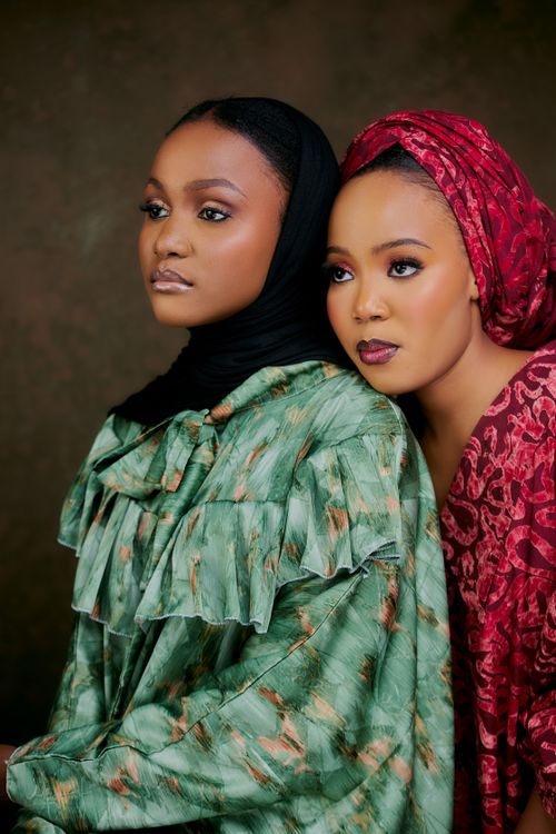 Free Beautiful portrait of two women in vibrant traditional clothing, creating a warm and elegant scene. Stock Photo