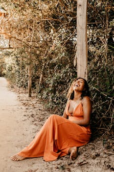 在巴西伊塔纳斯，一位身穿橙色连衣裙的女子面带微笑，享受着阳光明媚的一天