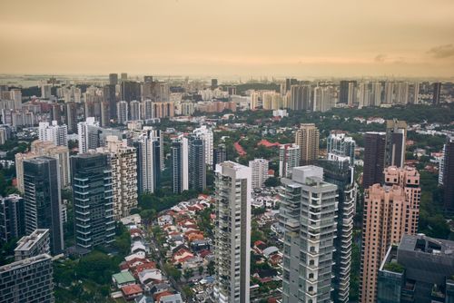 Free Scenic view of urban skyline with high-rise buildings and lush greenery at dusk. Stock Photo