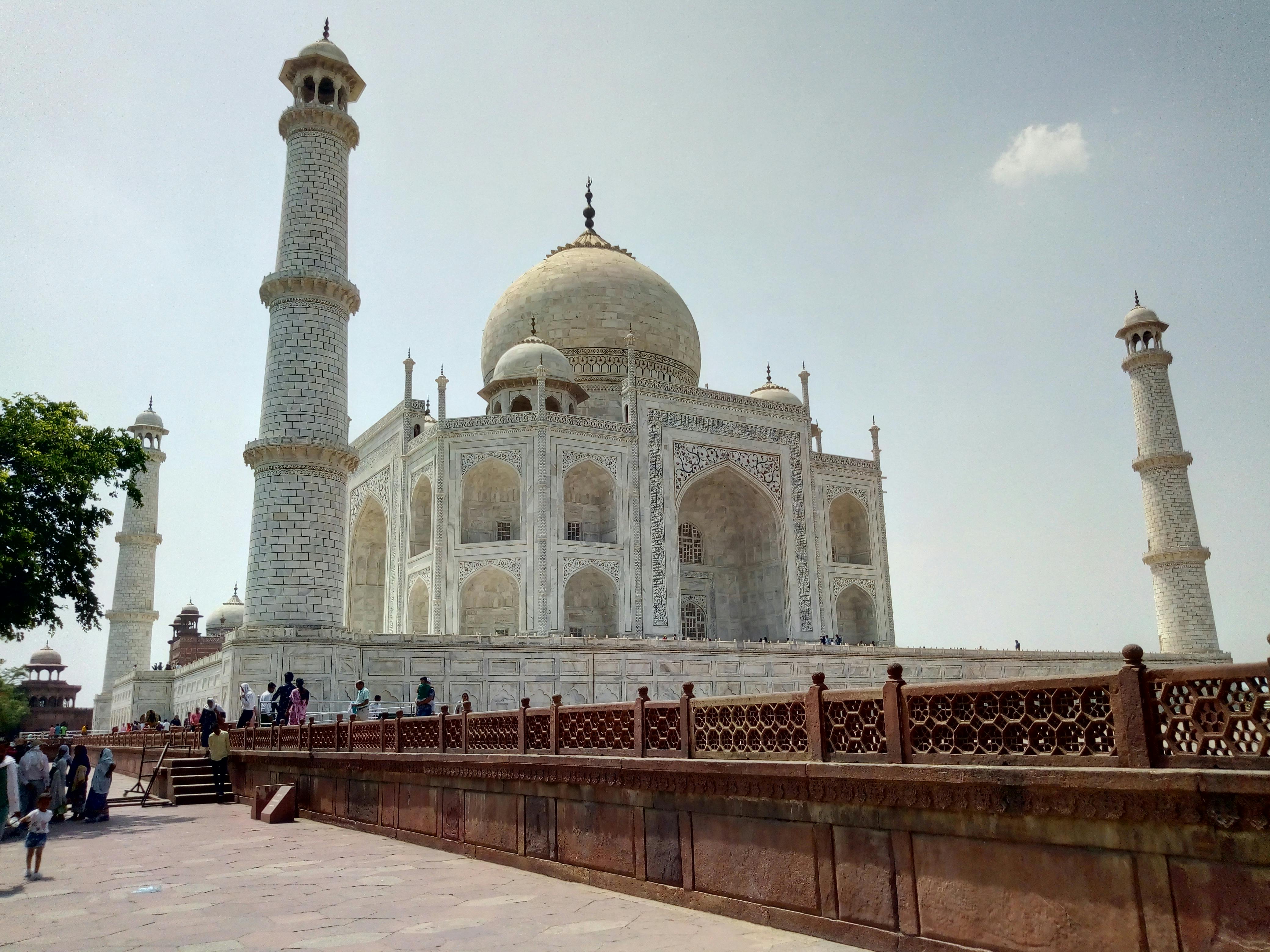 Beautiful view of the Taj Mahal with visitors on a sunny day in Agra, India.