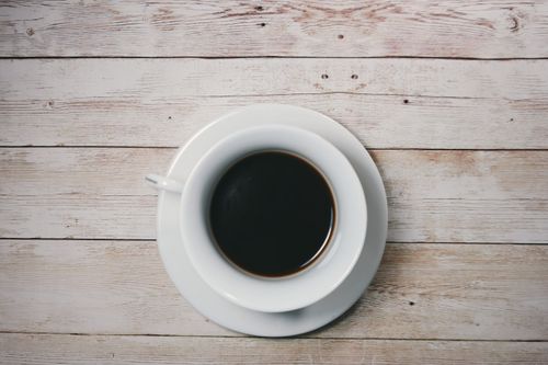 Free A cup of black coffee on a rustic wooden table, captured from above. Stock Photo