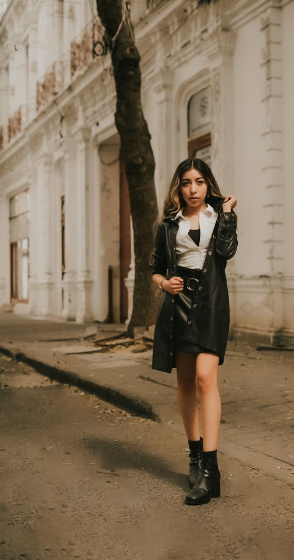 Woman in a black leather coat and black leather ankle boots on a quiet street — photo by brandon retratos on Pexels