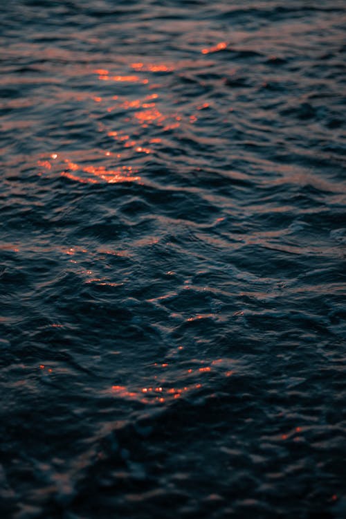 Gratis stockfoto met blauwe zee, donkere achtergrond, golfjes Stockfoto
