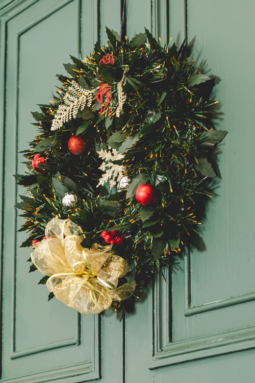 Free Vibrant holiday wreath with ornaments on classic green door. Stock Photo